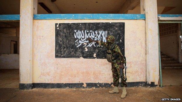 Kenyan troop points to a mural