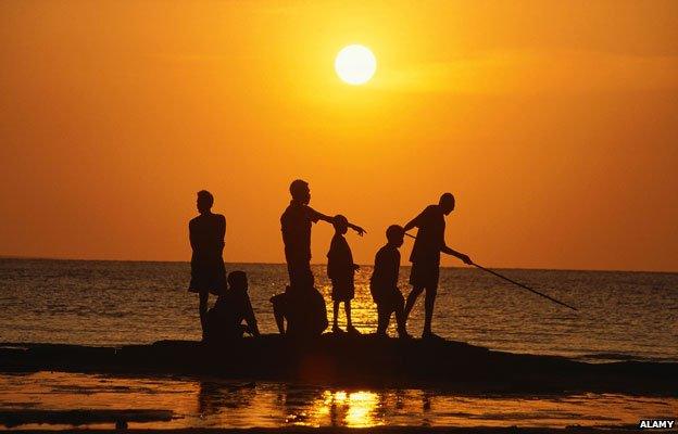 Aboriginal people fishing from rock outcrop, Galiwinku island, Arnhem Land