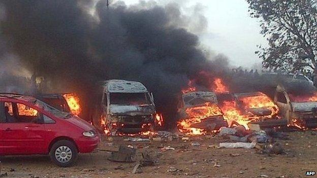 Vehicles burn after an attack in Abuja on 14 April 2014