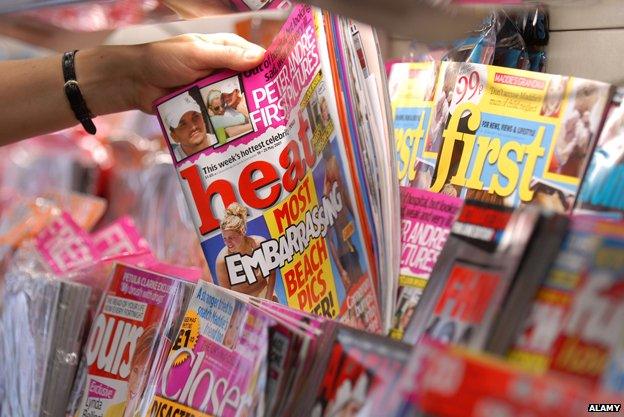 Hand picking gossip mag out of newsagent shelf