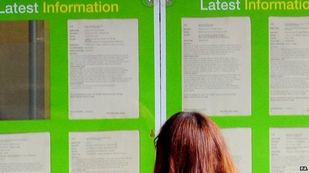 A woman looks at a JobCentre list of vacancies