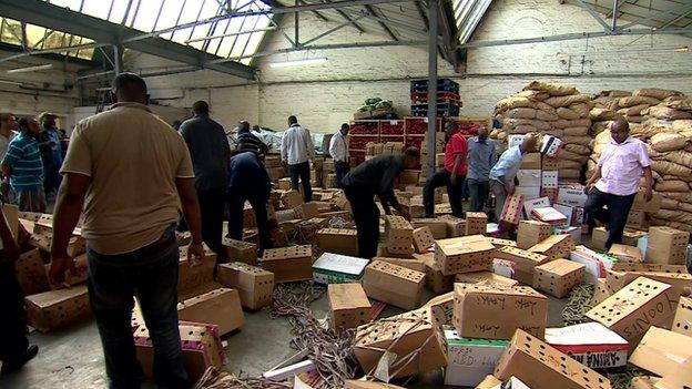 Men working among boxes of khat in west London depot