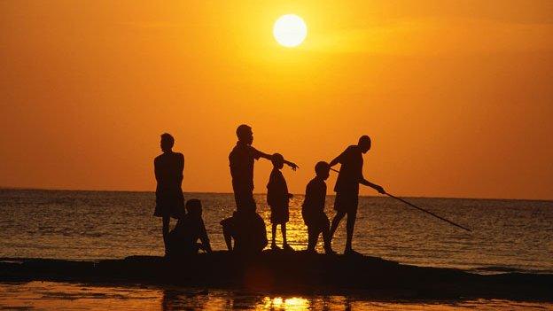 Aboriginal people fishing from rock outcrop, Galiwinku island, Arnhem Land