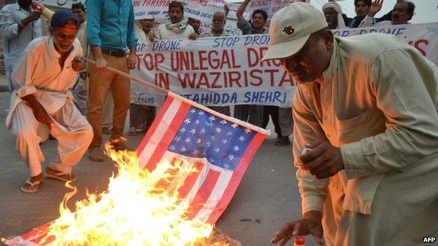 Pakistani demonstrators burn an American flag during a protest against a US drone strike - 12 June 2014