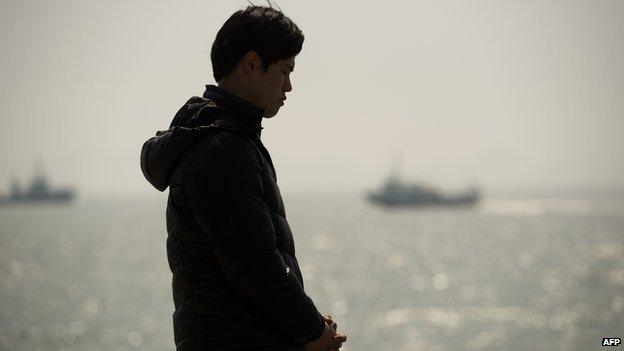 A relative of a passenger on board capsized South Korean ferry Sewol prays at an area where family members of victims of the disaster are gathered at Jindo harbour on 22 April, 2014