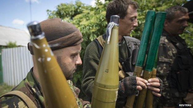Pro-Russian separatists hold rocket-propelled grenade projectiles near the town of Krasny Liman, Donetsk region, 19 June 2014