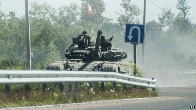 Pro-Russian troops ride on a tank in Donetsk region on June 2014