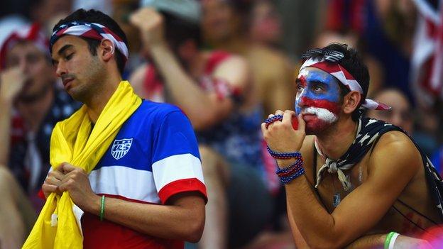 Two US fans look disappointed at the end of the match with Portugal.