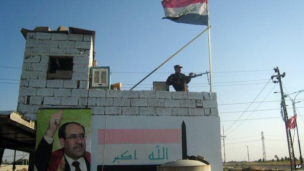 A member of the Iraqi security forces stands guard at the entrance checkpoint of the Bansher district, near the oil-rich city of Kirkuk, Iraq, on 20 June 2014