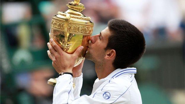 Novak Djokovic kisses the Wimbledon trophy