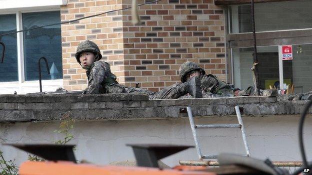 Troops take position as they search for a renegade South Korean soldier in Goseong, South Korea, 22 June 2014