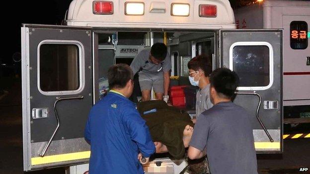 An injured soldier is lifted onto an ambulance in Goseong, Gangwon province, South Korea, early on 22 June 2014