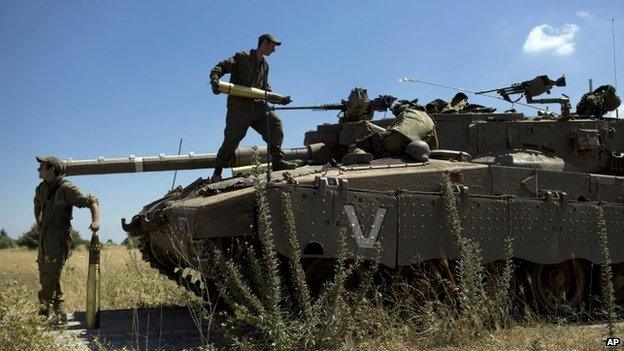 Israeli soldiers load shells in their tank in the Israeli-controlled Golan Heights, 22 June 2014