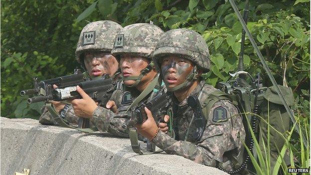 South Korean soldiers take position during a search and arrest operation at Goseong town as troops stand-off with a conscript soldier who shot and killed five comrades, on 23 June 2014.