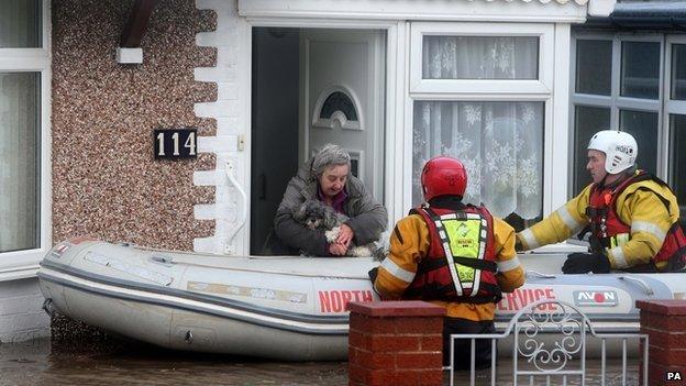 Rescuers help a woman in Rhyl