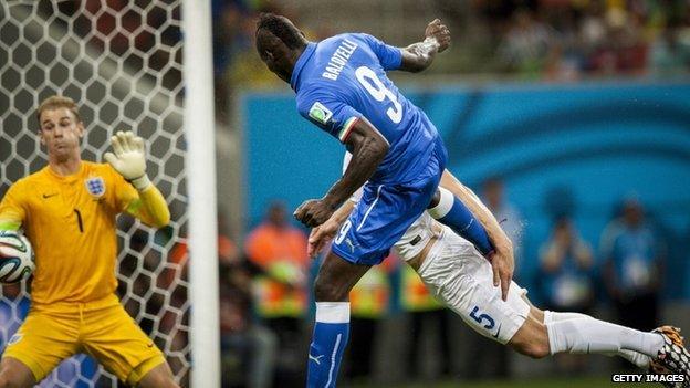 Italian striker Mario Balotelli heads the ball to score against England