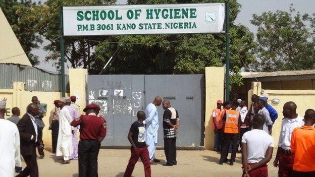 Policemen stand in front of the public health college in the northern Nigerian city of Kano where a bomb blast occurred on 23 June 2014.