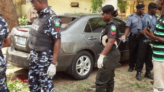 Policemen stand at the scene of a bomb blast at the public health college in thenorthern Nigerian city of Kano on 23 June 2014.
