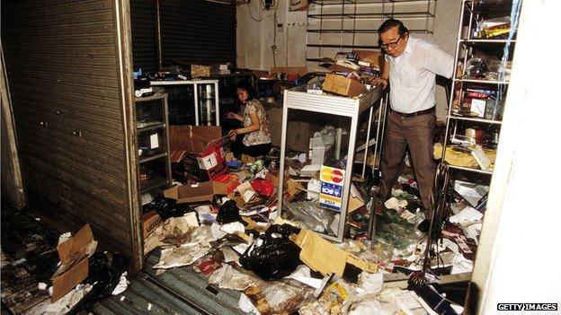 A Chinese store owner surveys the damage after a looting in Jakarta, Indonesia on 16 May 1998