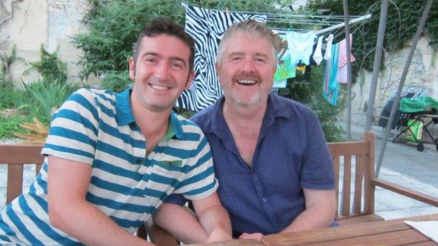 Paul and John sitting at a table on a patio