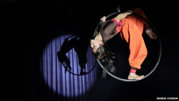 Circus performer upside down on ring