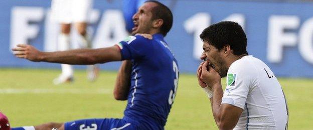 Luis Suarez holds his mouth after clashing with Girgio Chiellini