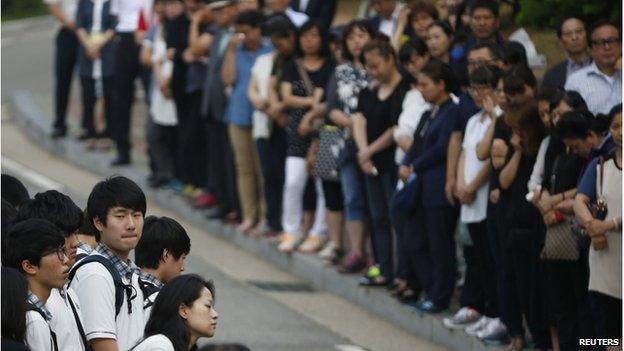 Students who survived the 16 April ferry disaster gather at the main gate as they make their way back to school in Ansan 25 June 2014.