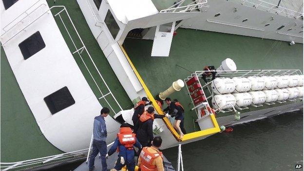 In this 16 April 2014 photo released by South Korea Coast Guard via Yonhap News Agency, South Korean coast guard officers rescue South Korean ferry Sewol Captain Lee Joon-seok, wearing a sweater and underwear, from the ferry in the water off the southern coast near Jindo, South Korea.