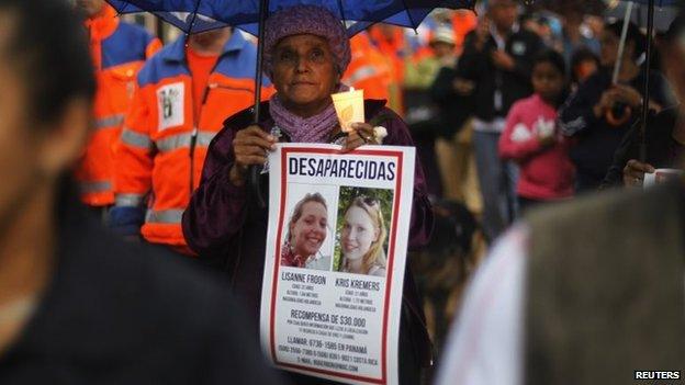 A local resident holds a candle and a missing person poster as she attends a public vigil to find two missing Dutch tourists in Boquete on 28 May, 2014