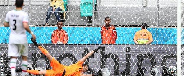 Edin Dzeko's shot goes beyond the despairing dive of Iran goalkeeper Alireza Haghighi