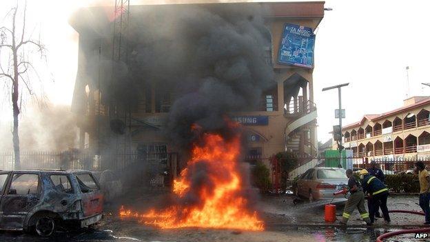 Firefighters try to put out a fire after a bomb exploded in a crowded shopping centre in Nigeria's capital Abuja on 25 June 2014.
