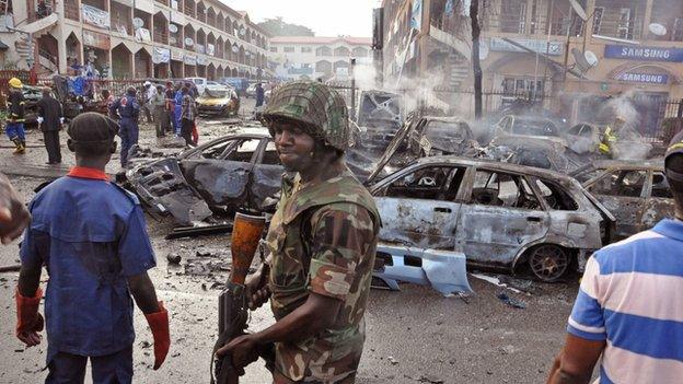 A Nigerian soldier walks at the scene of an explosion in Abuja, Nigeria, on 25 June 2014