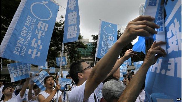 Pro-democracy supporters raise banners that read: "Occupy Central with Love and Peace," during a kickoff ceremony of an referendum on democracy under a plan of Occupy-style protest in Hong Kong (20 June 2014)