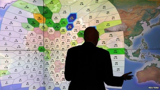 File photo: A member of staff at satellite communications company Inmarsat works in front of a screen showing subscribers using their service throughout the world, at their headquarters in London, 25 March 2014