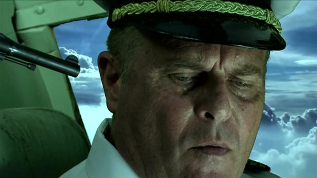 A still from the film, with the British pilot at gunpoint