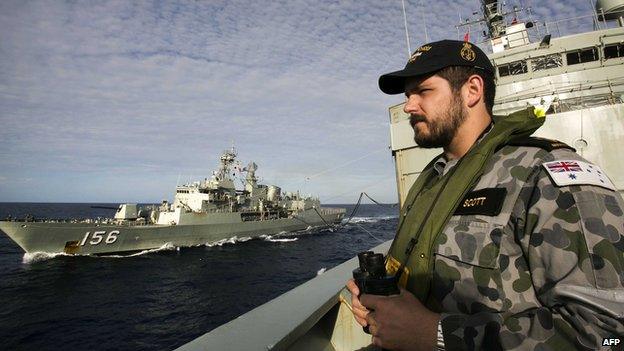 A file handout photo taken on April 7, 2014 and released on April 11 by the Australian Defence shows Able Seaman Maritime Logistics Steward Kirk Scott keeping watch on the forecastle of auxiliary oiler HMAS Success as they conduct a Replenishment at Sea with HMAS Toowoomba whilst both ships are deployed in search of the missing Malaysia Airlines Flight MH370 in the southern Indian Ocean