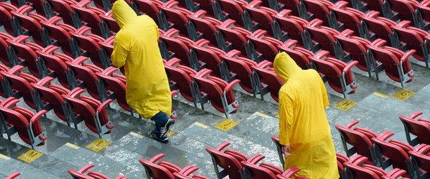 Stewards attempt to clear water from the stand