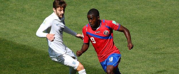 Joel Campbell evades the challenge of England's Adam Lallana