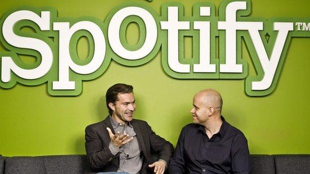 Spotify founders sitting in front of logo