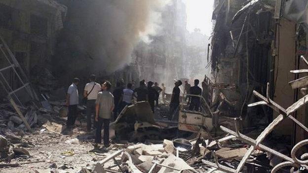 Syrians inspected a site amid the rubble of destroyed buildings following a Syrian government airstrike at Karm al-Jabal area in Aleppo, Syria, on 26 June 2014