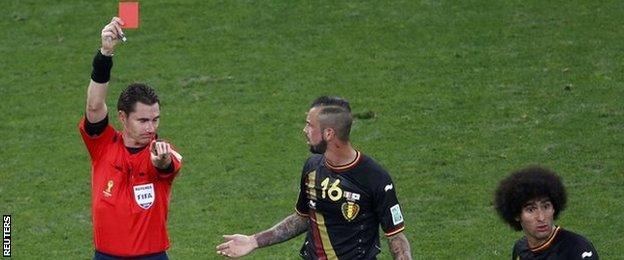 Belgium midfielder Steven Defour (centre) is sent off during the game against South Korea