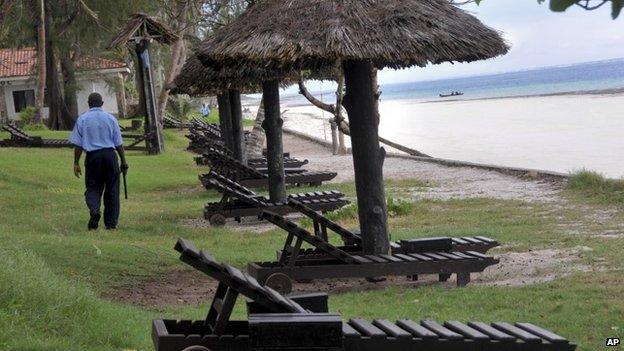 A security guard walks past empty sun loungers facing the Indian Ocean at a holiday resort in the town of Diani, south of Mombasa, on the coast of Kenya Thursday 22 May 2014