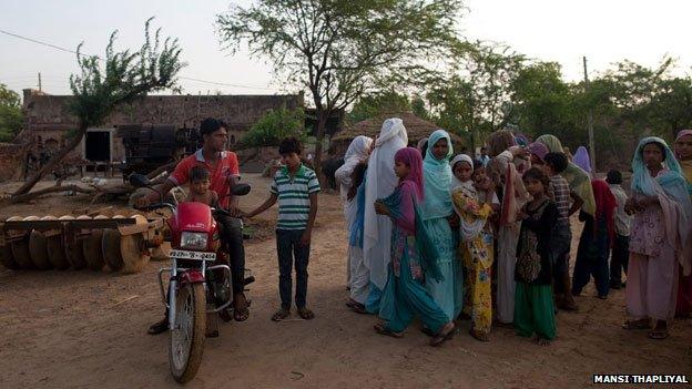 Man with motorbike and village girls