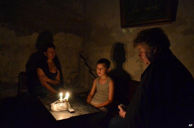 People sit in a bomb shelter in the besieged rebel stronghold of Sloviansk, eastern Ukraine, 22 June