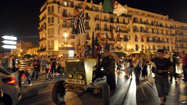 An Algerian football fan celebrating on a tractor in Algiers - 26 June 2014