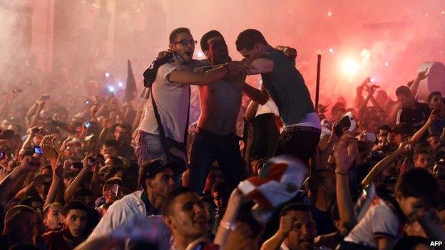 Algerian fans celebrate in Algiers on 26 June 2014 after Algeria eliminated Russia with a 1-1 draw in a Fifa 2014 World Cup Group H match