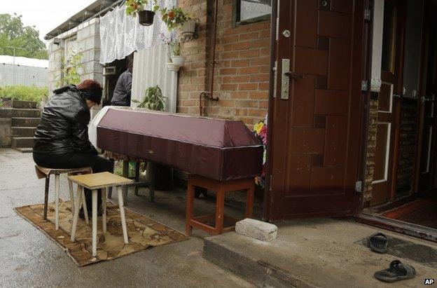 A woman grieves by the coffin of her daughter, 46, said to have been killed in a Ukrainian mortar attack on Sloviansk, 24 June