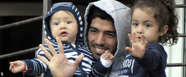 Luis Suarez waves to fans who came to show their support to him following his return to Uruguay