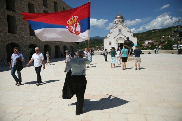 A man waves a Serbian flag as he walks through the mock-village of Andricgrad in Visegrad, Bosnia and Herzegovina - 28 June 2014