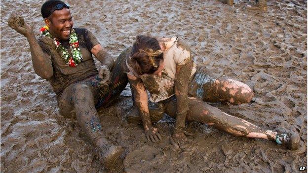 Two people covered in mud at Glastonbury music festival